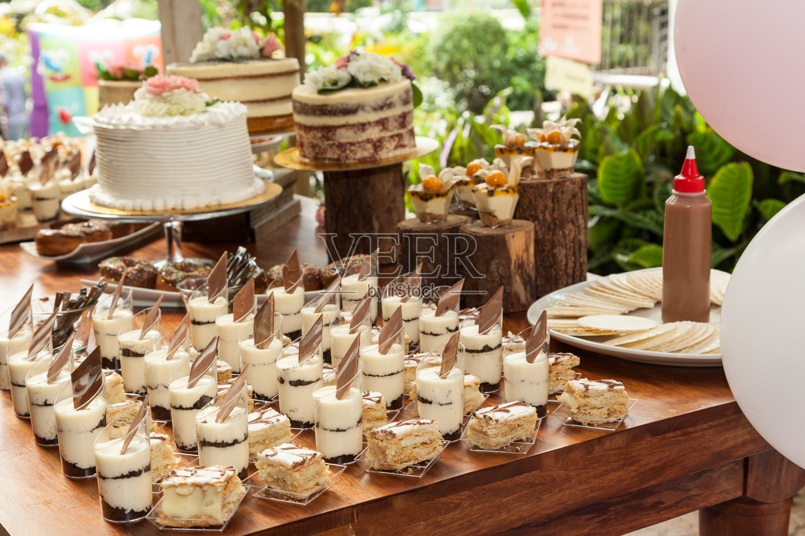 餐桌上摆放着糖果、甜点和蛋糕，为接待客人装饰餐桌。照片摄影图片