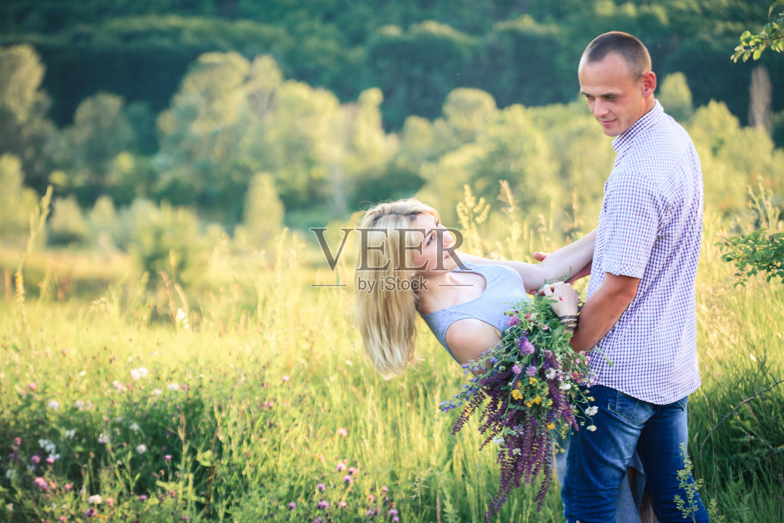 男人和女人捧着一束鲜花，谈论着大自然。夫妇在爱。照片摄影图片