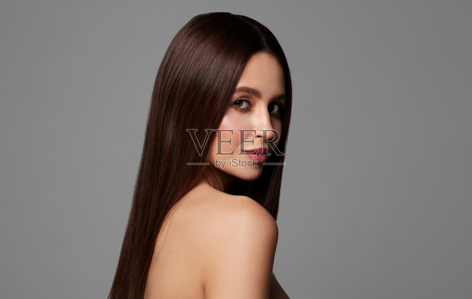 年轻美丽的女人与大眼睛看着相机孤立在灰色的背景照片摄影图片