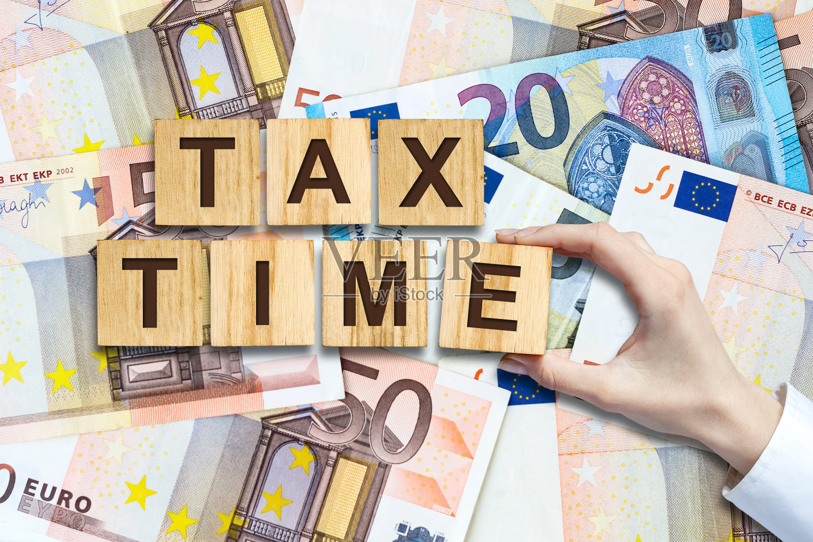 纳税时间。欧洲钞票背景木块上的题词。业务。融资。照片摄影图片