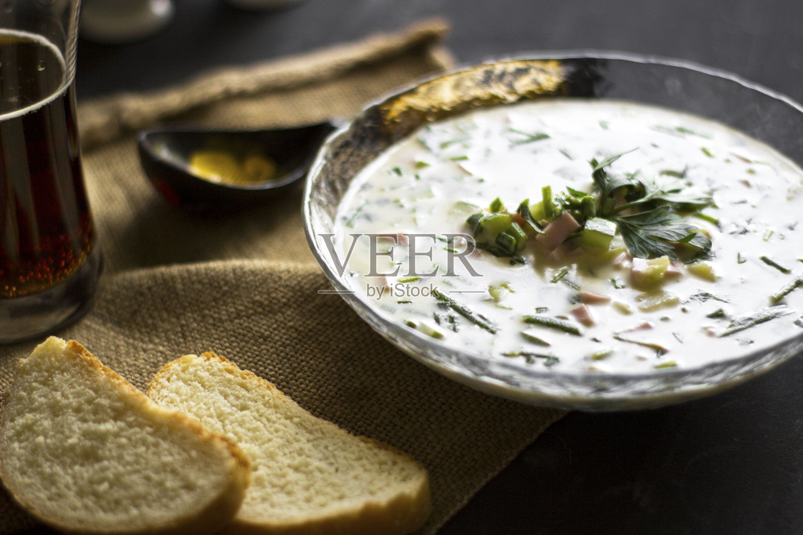 Okroshka冷汤。香肠，蔬菜和格瓦士一碗一份，原料放在木桌上照片摄影图片