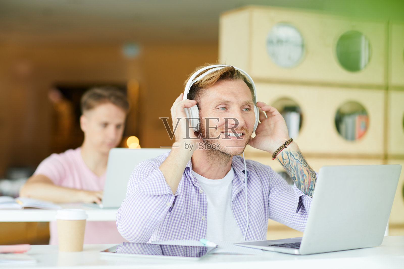 戴着耳机在图书馆做项目的积极家伙照片摄影图片