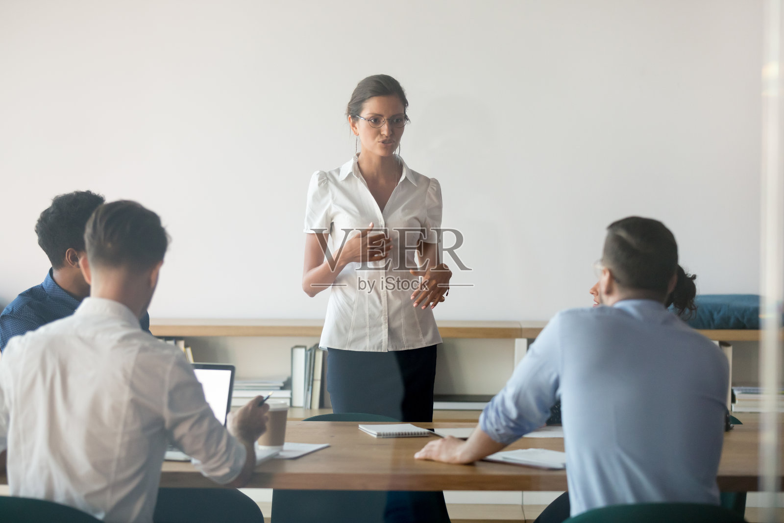 严肃的女发言人在会议上与员工合作照片摄影图片