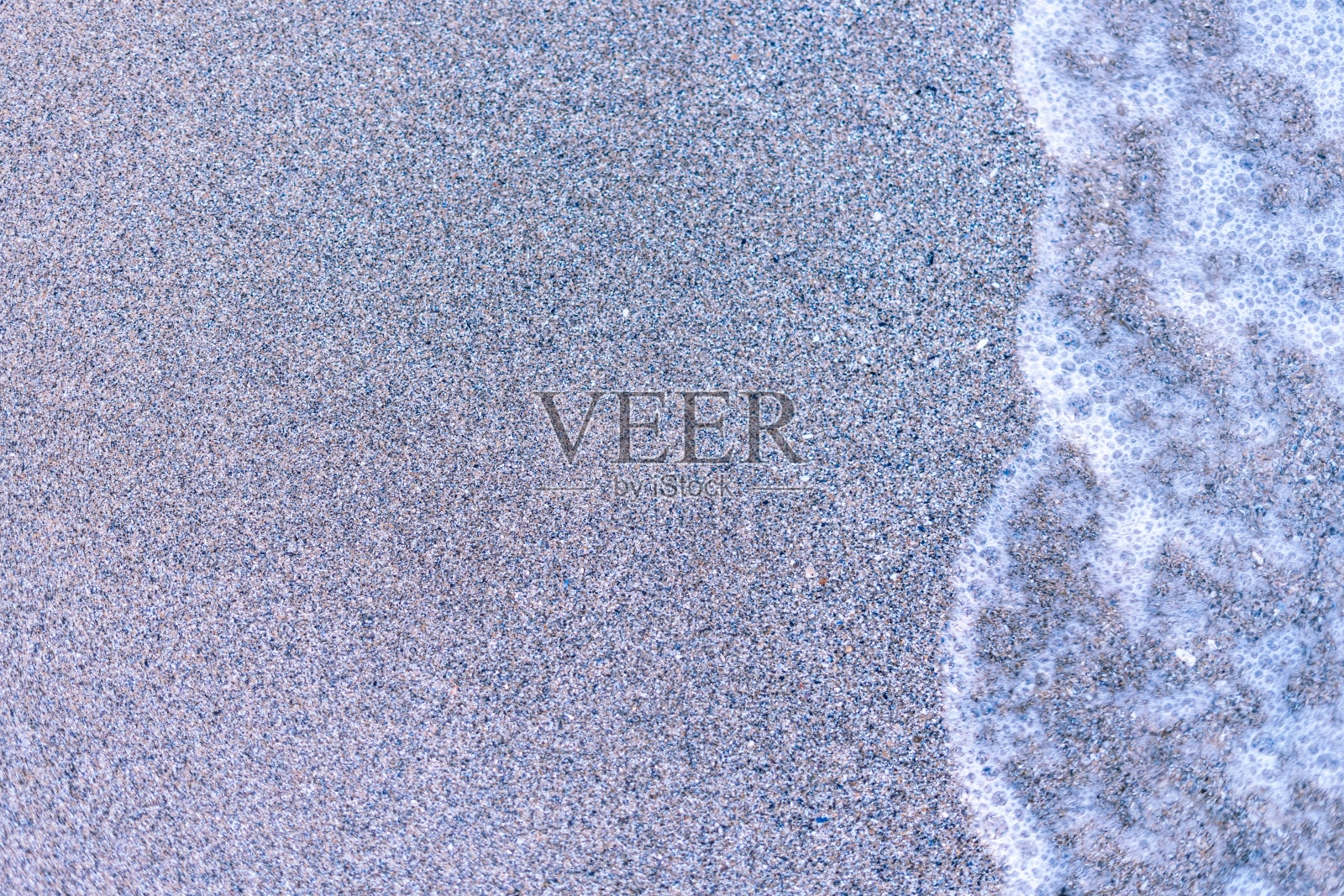 沙滩上的沙子和海水的波浪。创造性的背景。照片摄影图片