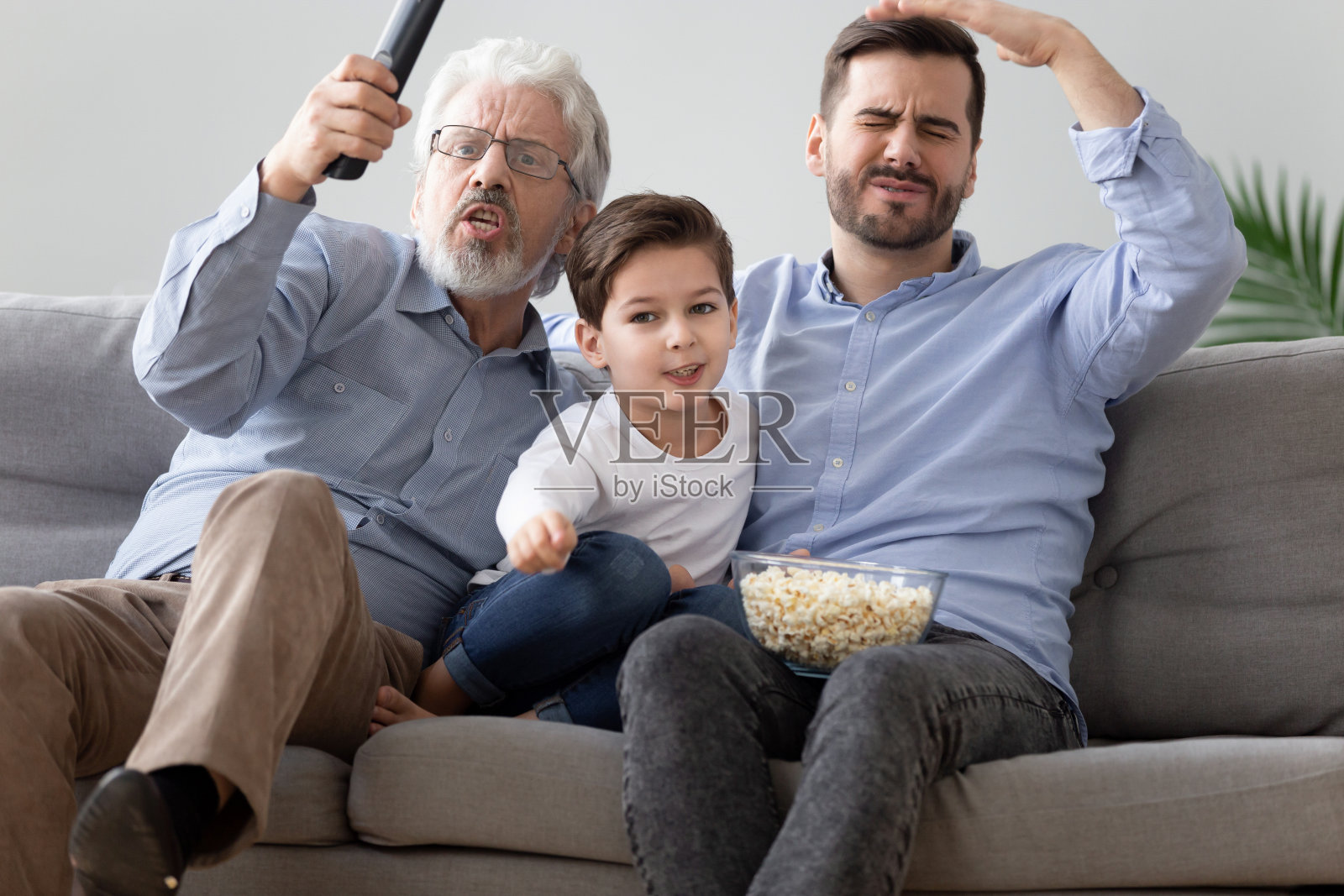 三代男人一起在家看足球照片摄影图片