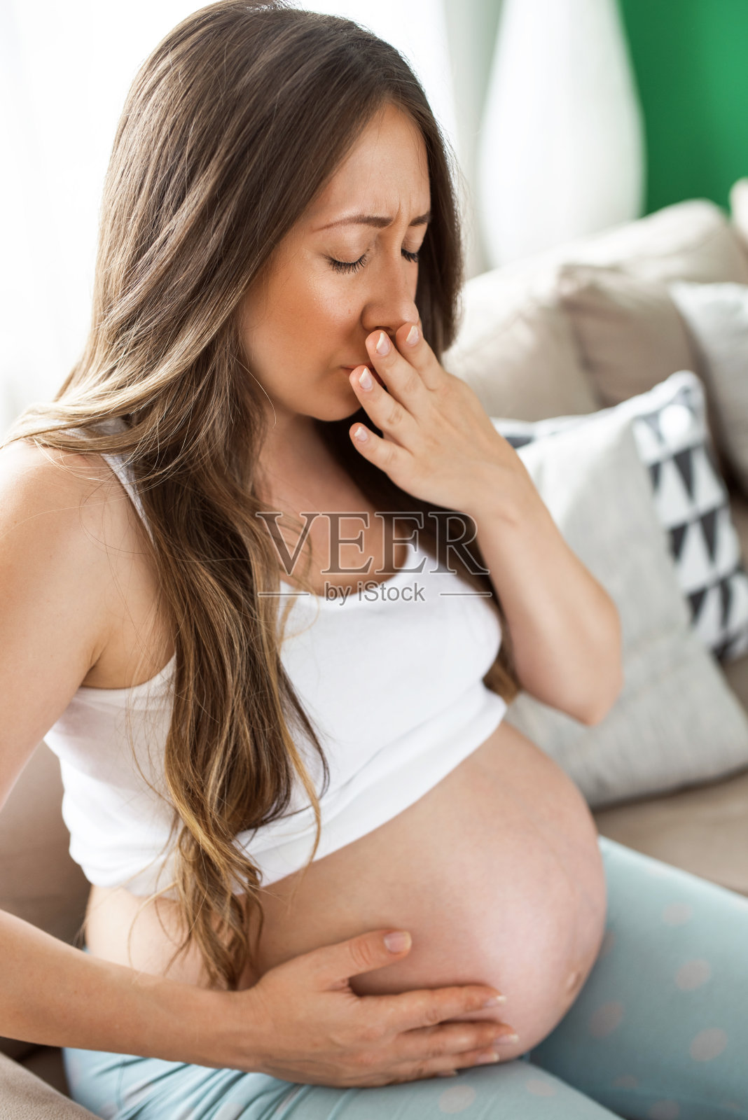 年轻孕妇坐在床上在家感觉不舒服照片摄影图片