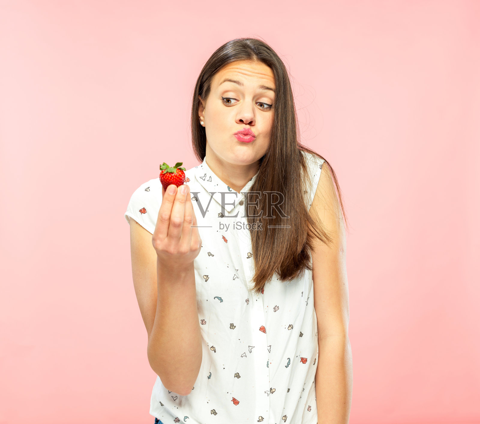 抱着草莓的年轻女子照片摄影图片