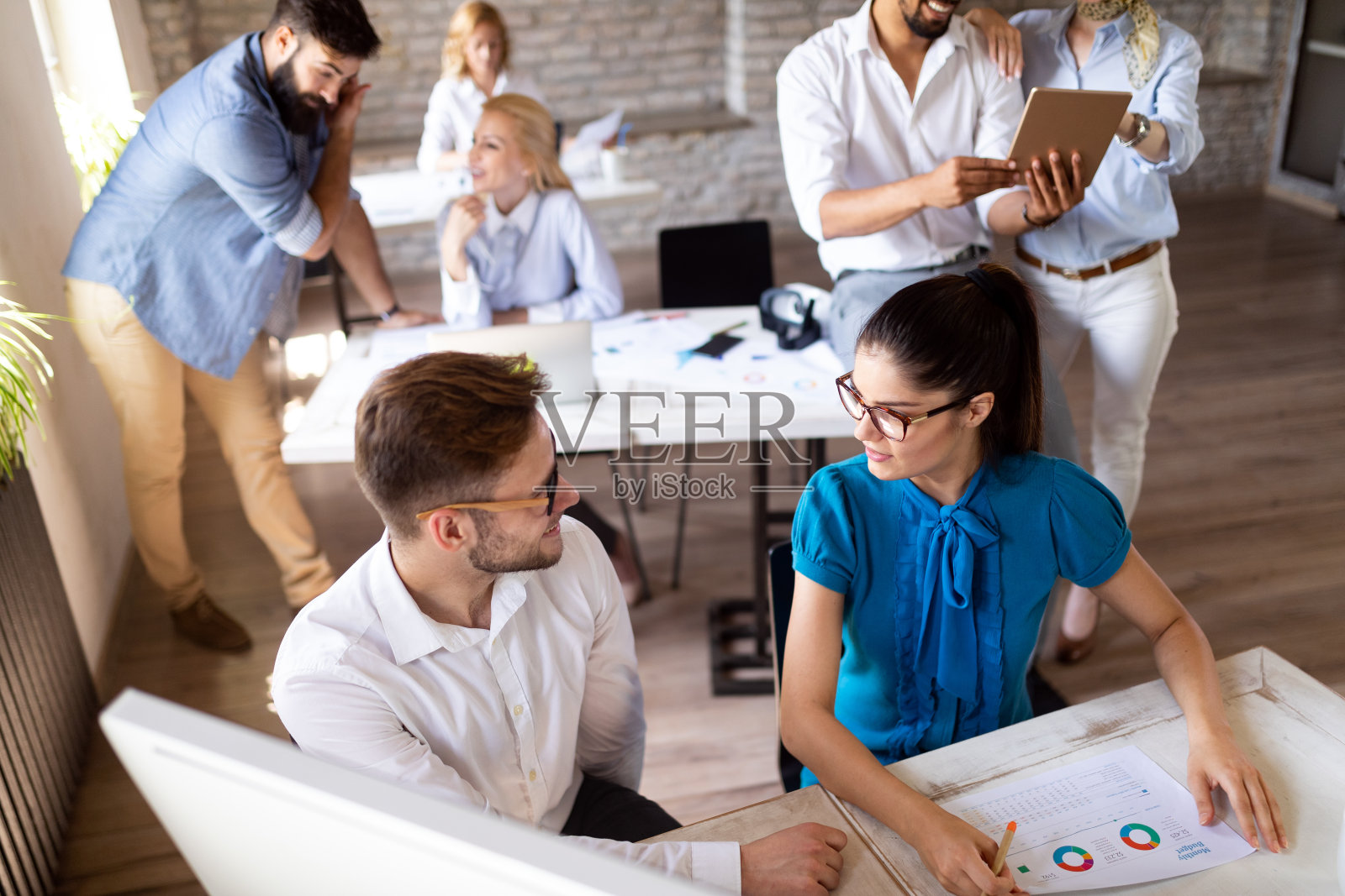 创业团队在现代明亮的办公室里开会，头脑风暴，在电脑上工作照片摄影图片