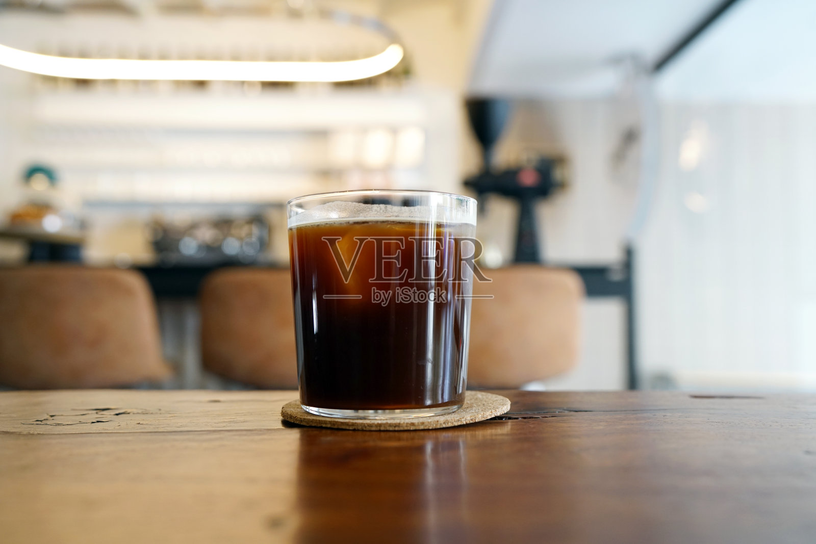 在桌子和复印空间上放一杯冰美式咖啡，这种咖啡的风格是用浓缩咖啡和水混合而成。照片摄影图片