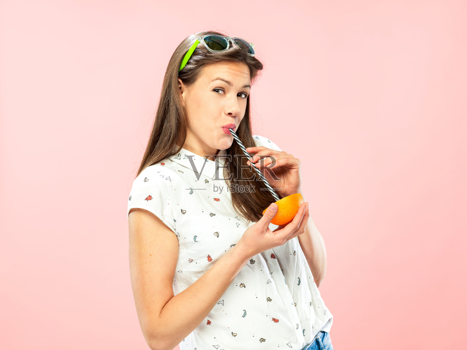 用可重复使用的吸管喝半杯橙汁照片摄影图片