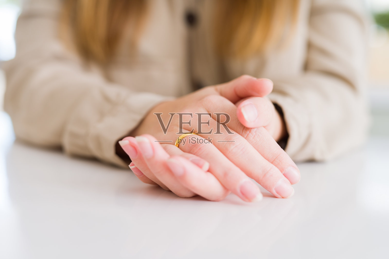 近距离的女人的手显示金色联盟与手在彼此在白色的桌子照片摄影图片