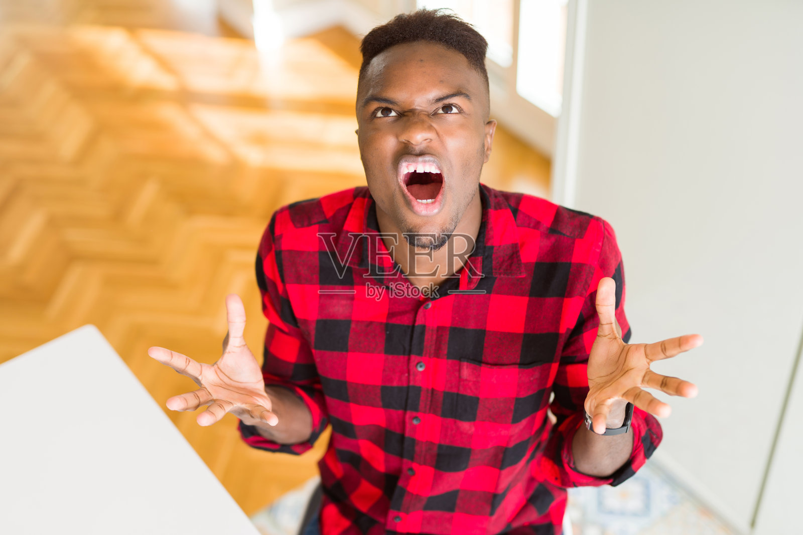 头顶的角度英俊的非裔美国人疯狂和疯狂的大喊大叫与侵略性的表情和手臂举起。挫折的概念。照片摄影图片