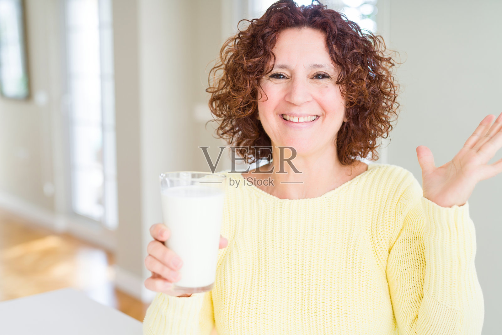 老妇人喝了一杯鲜牛奶非常高兴和兴奋，胜利者的表情庆祝胜利尖叫着大大的微笑，举起了双手照片摄影图片