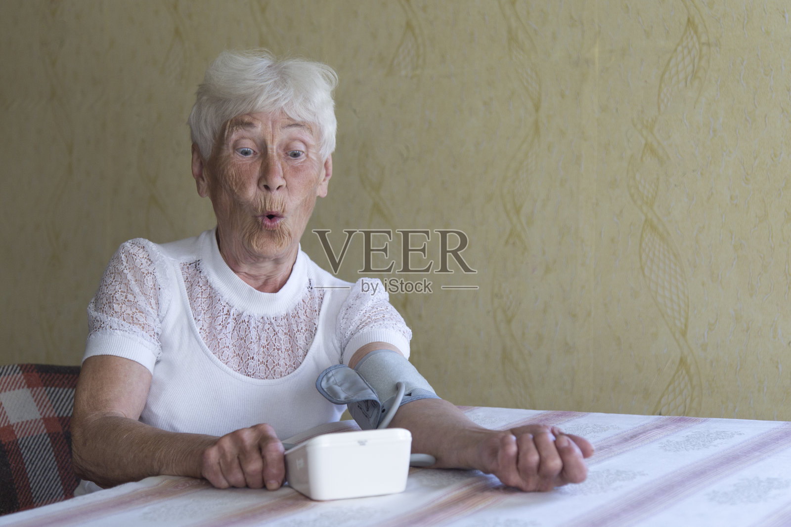 一位上了年纪的妇女在测量血压。照片摄影图片