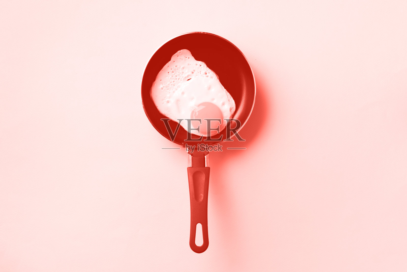 创意的食物概念，平底锅煎蛋，时髦的珊瑚色背景。前视图。极简风格的创意图案。平躺照片摄影图片