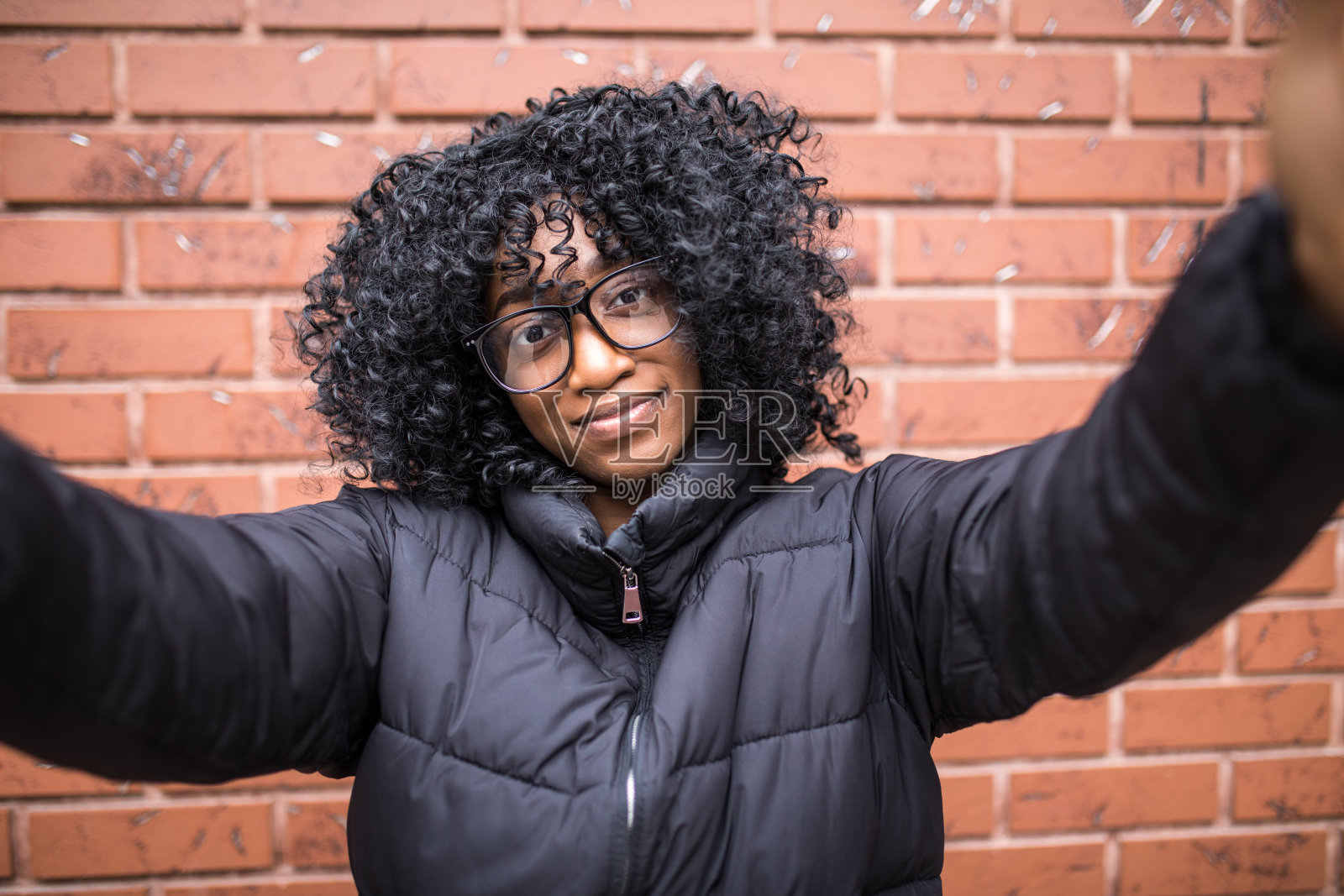 年轻迷人的非洲女子在砖墙背景上自拍照片摄影图片