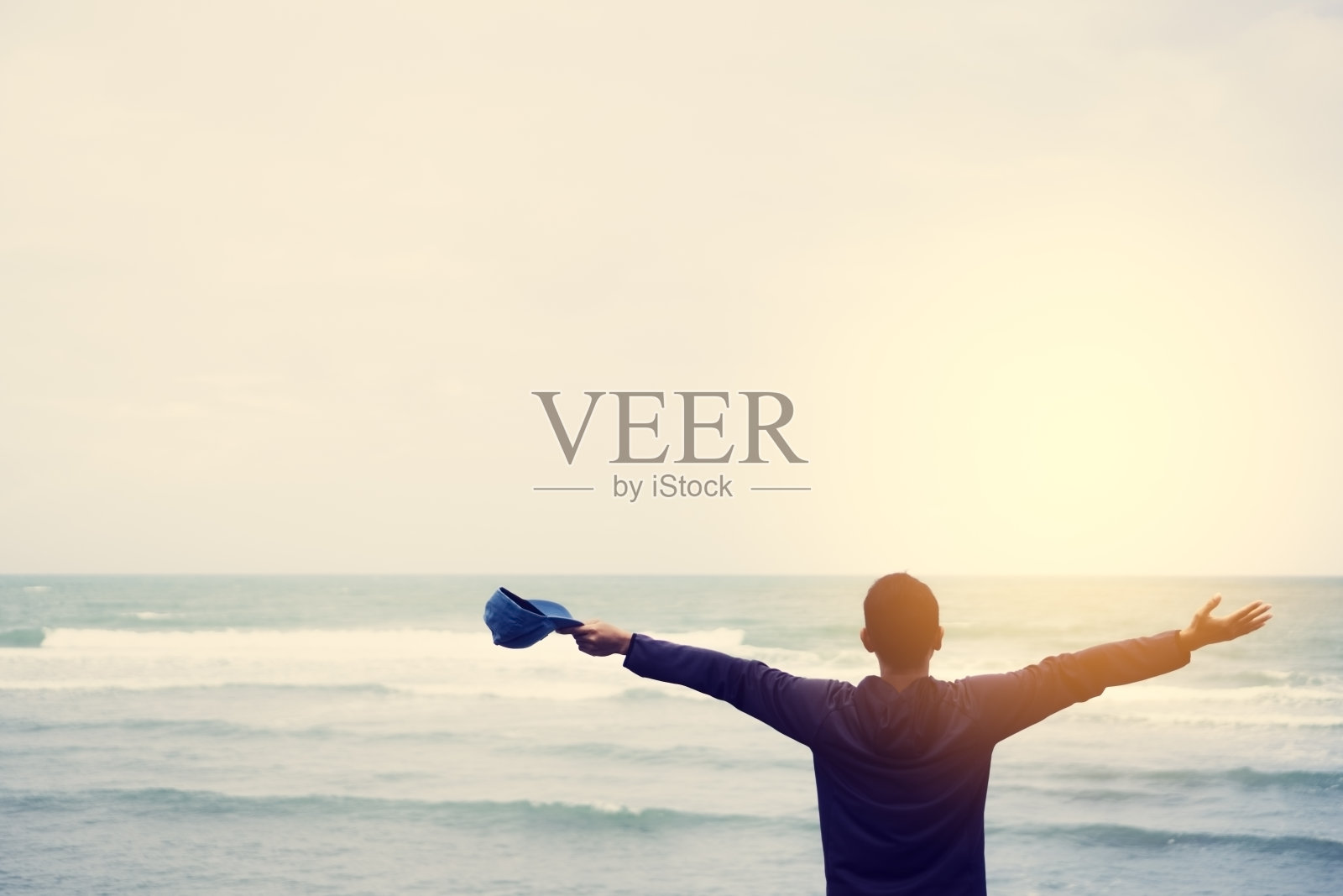 感觉良好和自由的概念。在海滩背景上复制快乐男子举手的空间。复古色调滤色风格。照片摄影图片