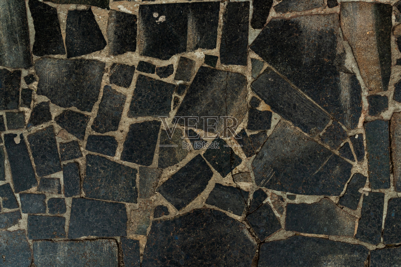 人行道的纹理杂乱，不同颜色的花岗岩石头有许多裂缝照片摄影图片