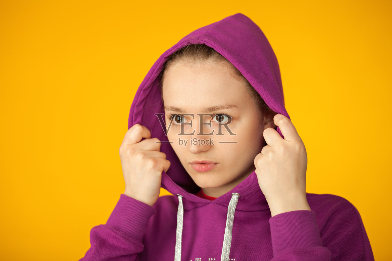 一个迷人的18岁女人在黄色背景的工作室肖像照片摄影图片