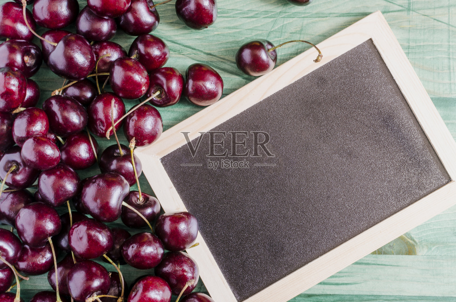 成熟的樱桃在绿色木质背景上顶视图深色文字板照片摄影图片