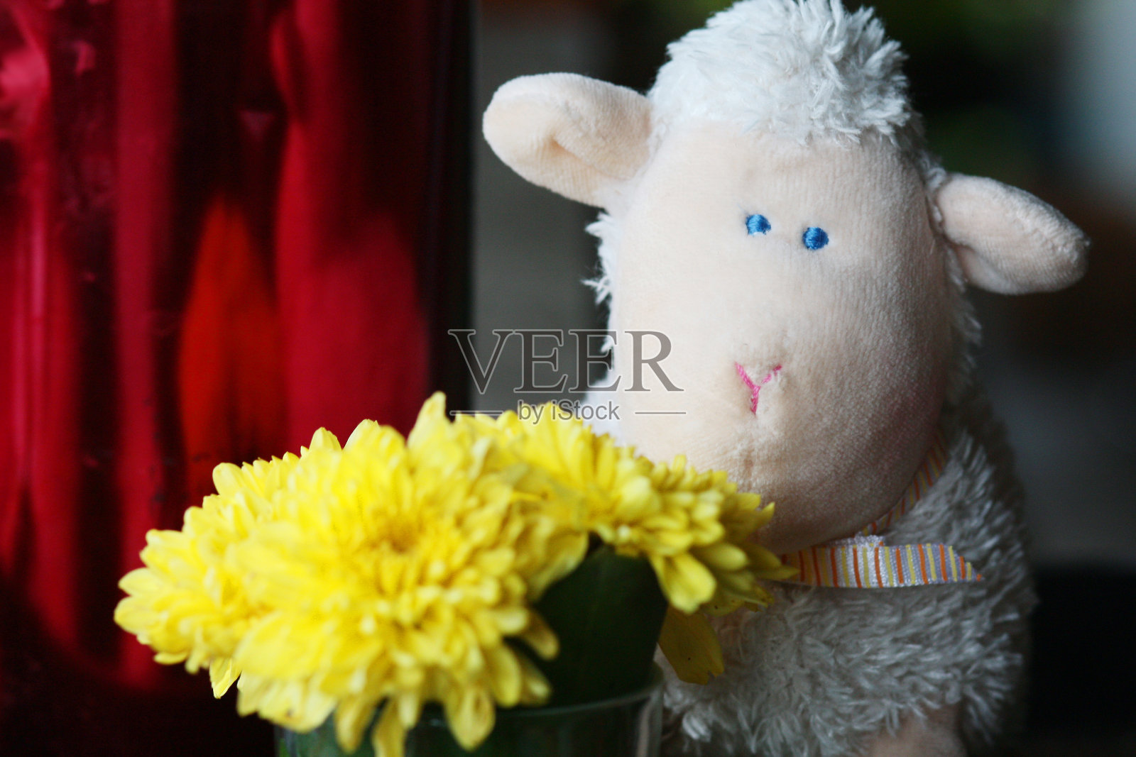 咖啡店的彩色桌布和桌子上装饰着黄色花朵的快乐羊娃娃照片摄影图片