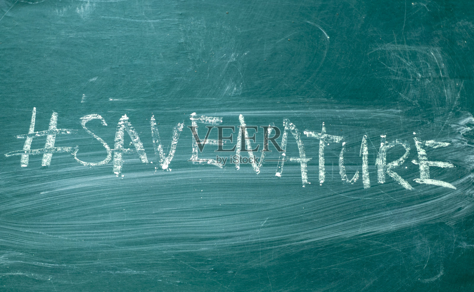 “拯救自然”的标签用白色粉笔手写在绿色的黑板上照片摄影图片