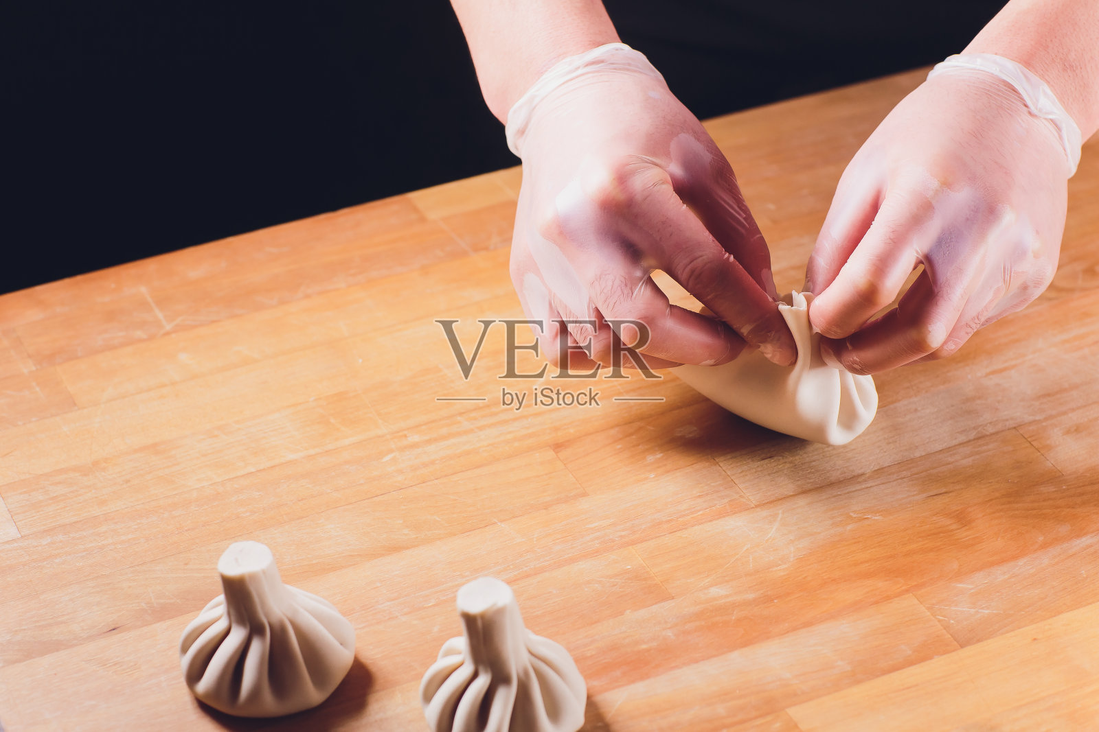 格鲁吉亚国菜Khinkali金属背景厨师准备Khinkali厨房俯视图生肉面团菜生鲜食品摊位出售中国特色蒸饺工艺烹饪。在手套。照片摄影图片