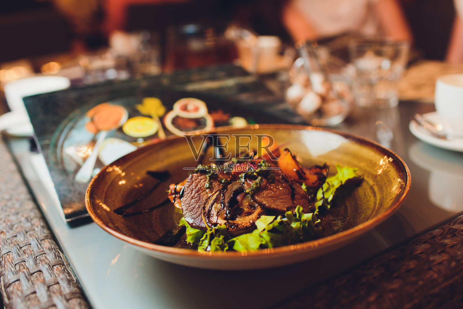 一个新鲜的绿色沙拉与切片烤里脊牛排的特写。照片摄影图片