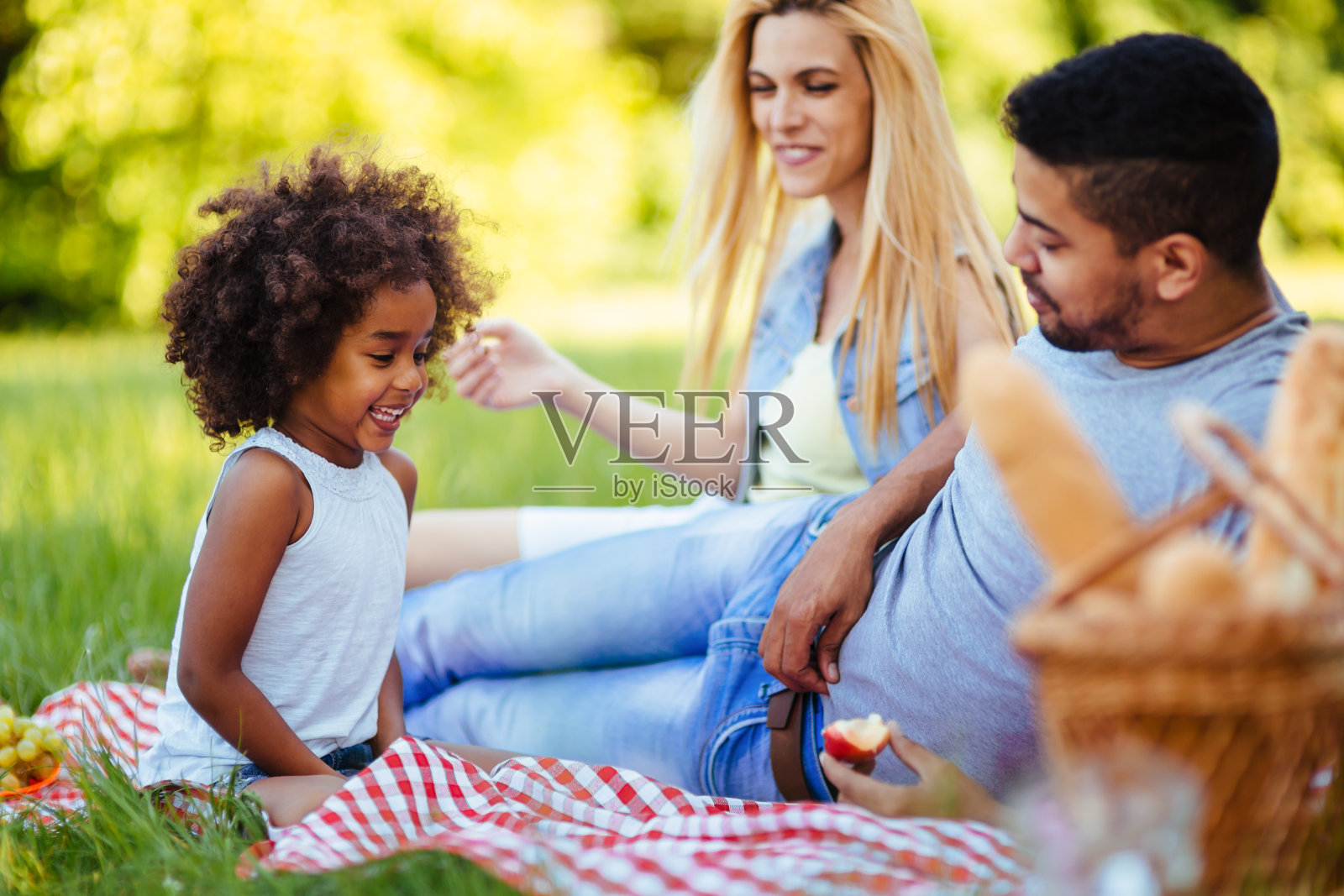图为一对可爱的夫妇和他们的女儿在野餐照片摄影图片