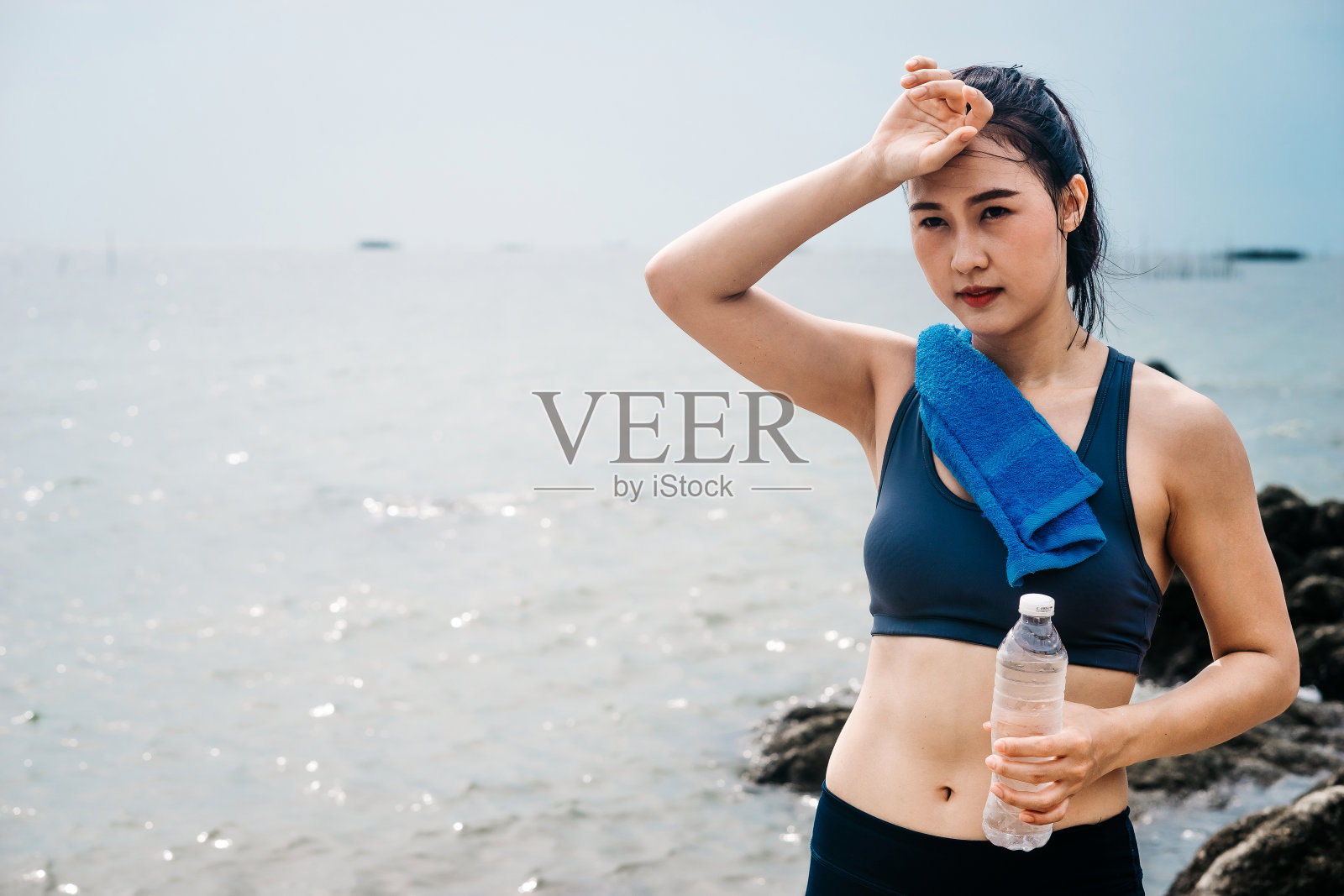 亚裔白人妇女在海滨练习瑜伽早上她的一些周末假期。照片摄影图片