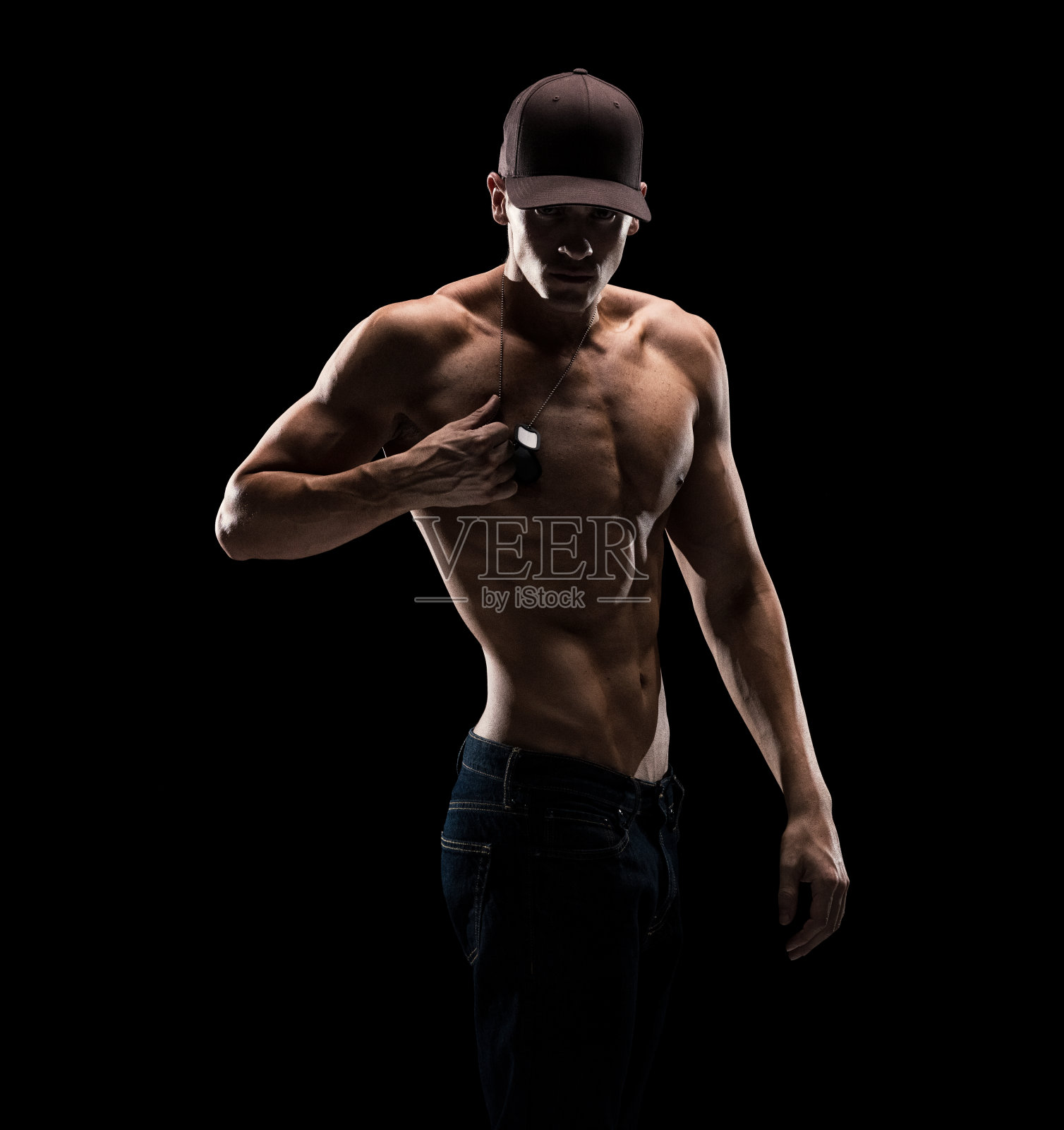 非常有吸引力的性感的赤膊男子穿着牛仔裤，狗牌，和帽子上的黑色背景照片摄影图片