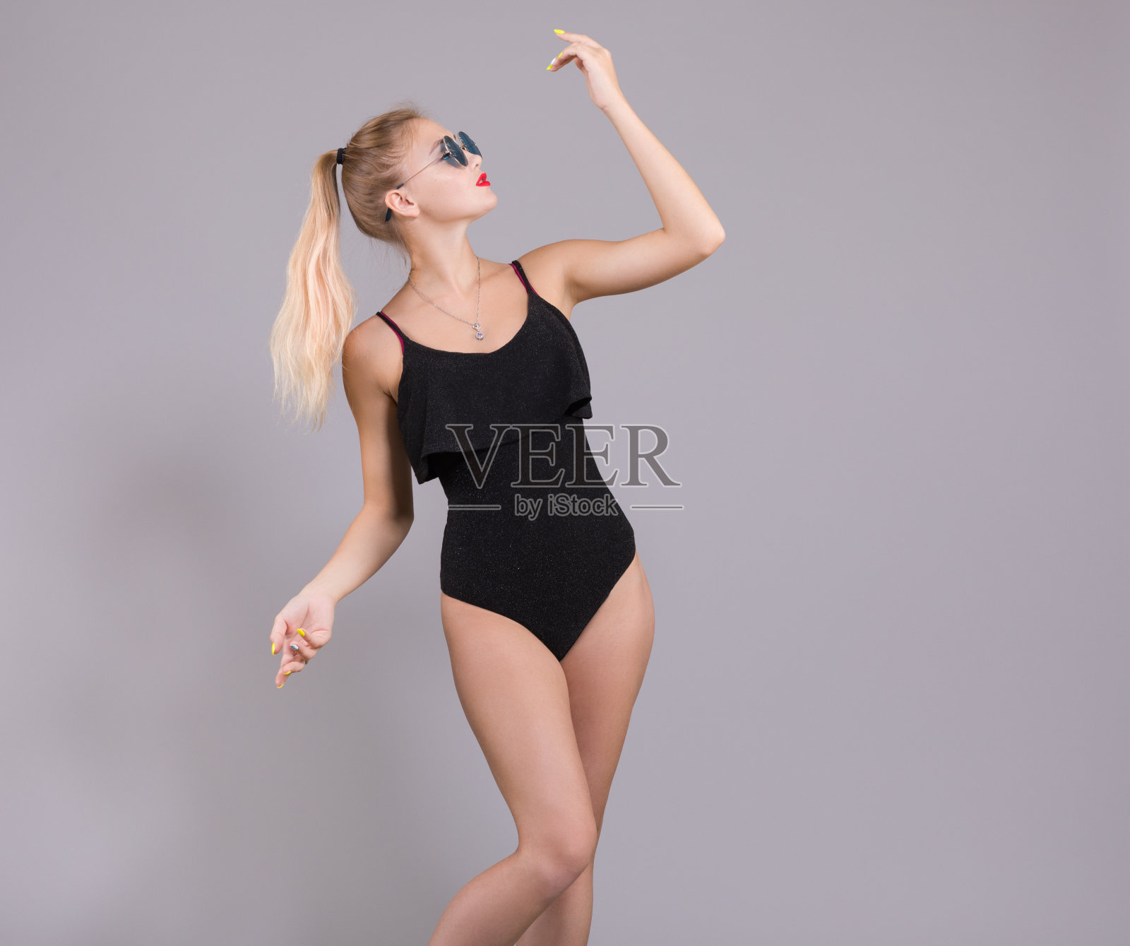 穿着黑色泳衣，戴着白色帽子和太阳镜的优雅女人。照片摄影图片