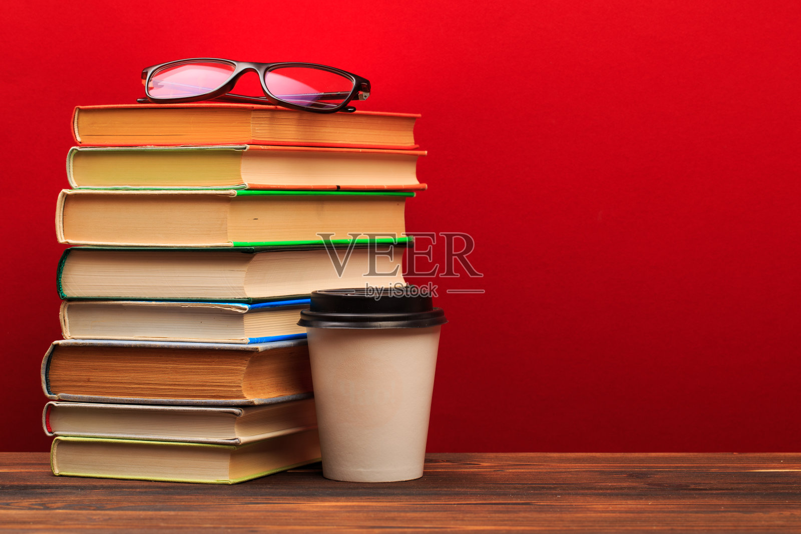 一堆旧书与马克杯，全景，良好的复制空间上的红色背景-图像照片摄影图片