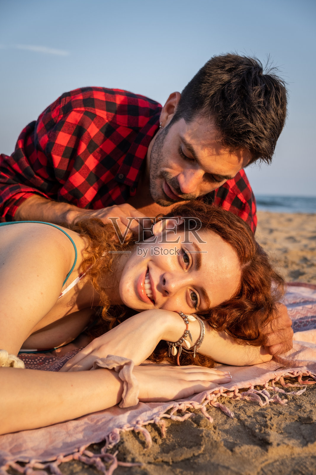 年轻夫妇在地中海海滩的沙滩上浪漫的态度在日落照片摄影图片