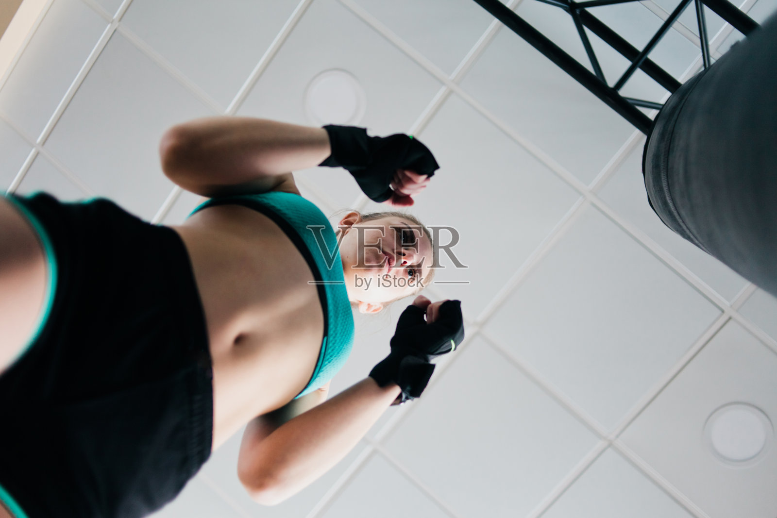 健康的女人用沙袋打她的拳头，拳击。底视图照片摄影图片