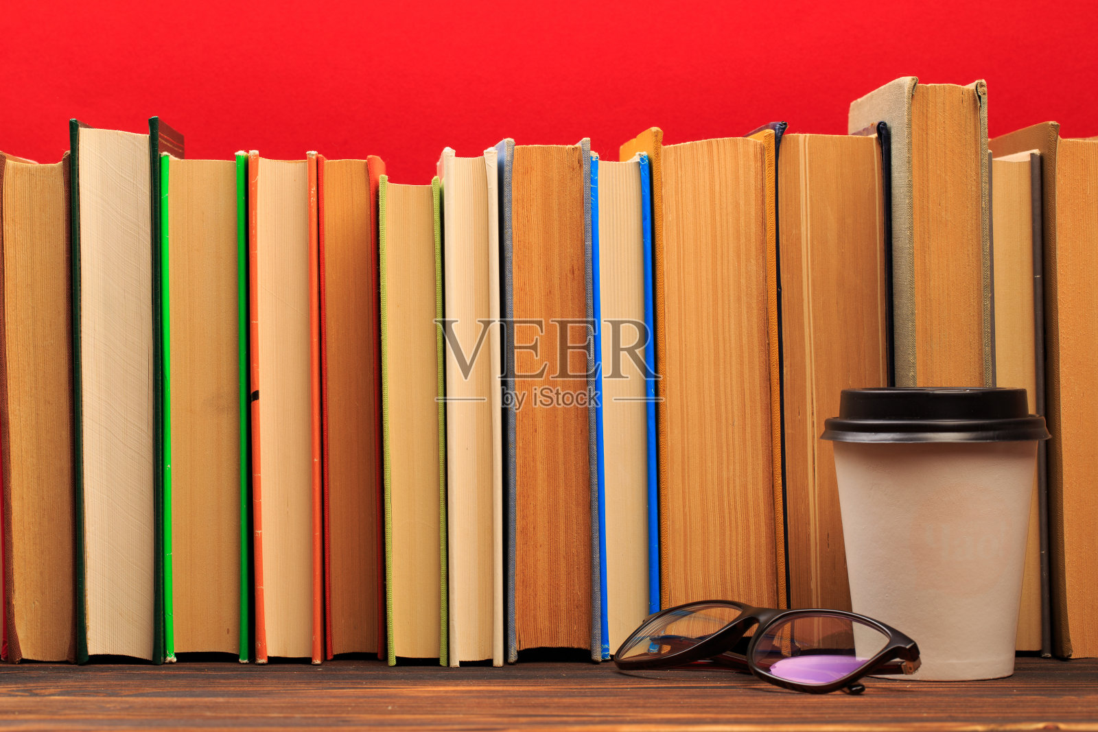 简单的组成精装书，原始的书在木制甲板桌子上与马克杯在红色的背景-图像照片摄影图片