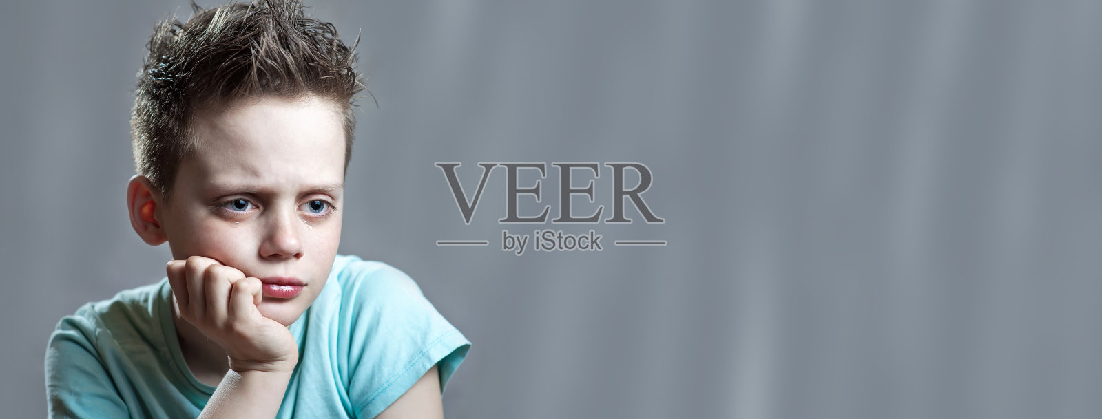 一个穿着鲜艳t恤的男孩生气地哭了起来照片摄影图片