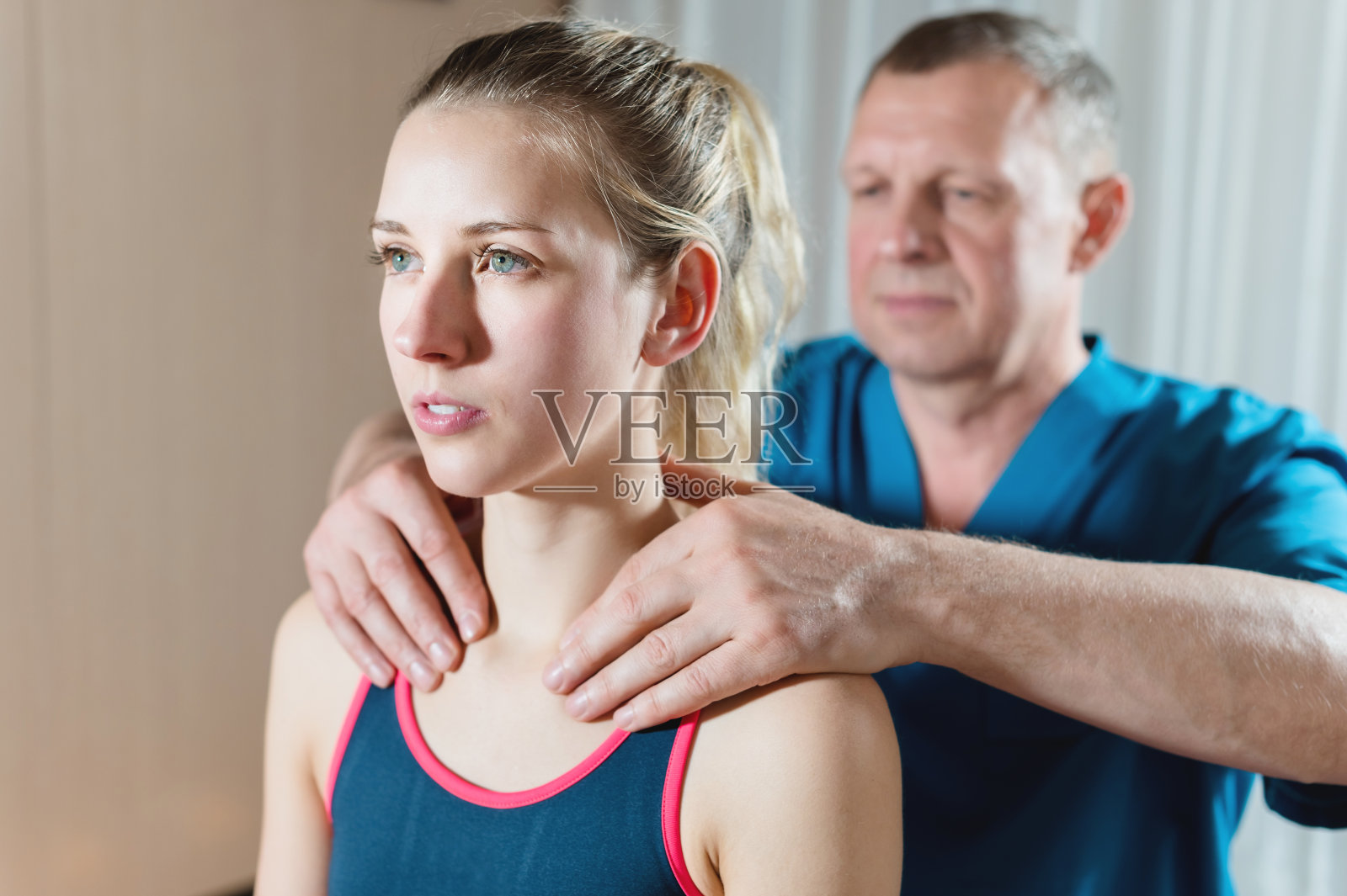 男性手工内脏治疗师按摩治疗一个年轻的女性病人。照片摄影图片