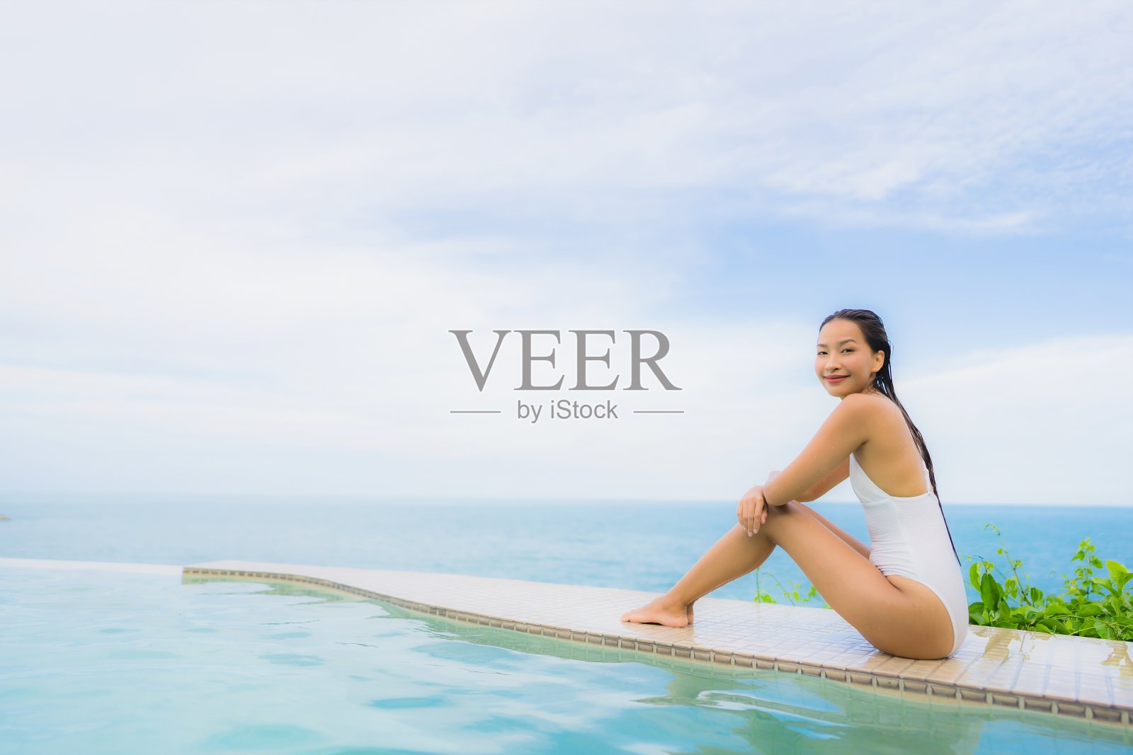 肖像年轻的亚洲女人放松微笑快乐周围的户外游泳池在酒店度假海景照片摄影图片