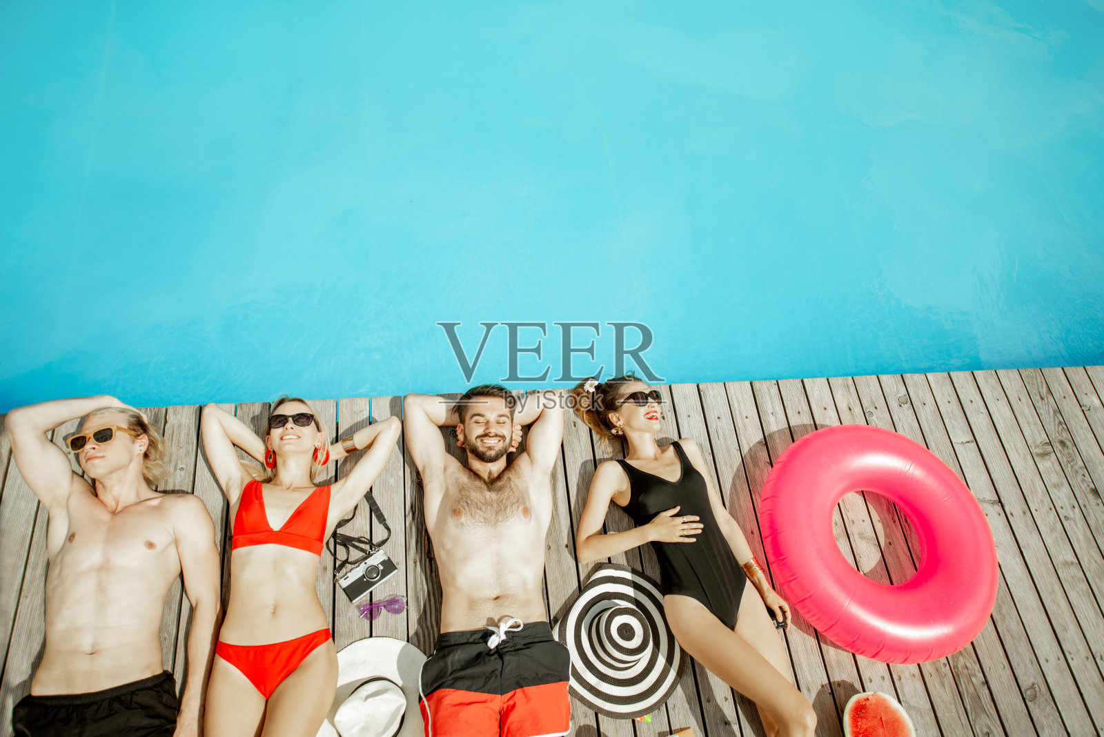 朋友们在游泳池里晒日光浴照片摄影图片