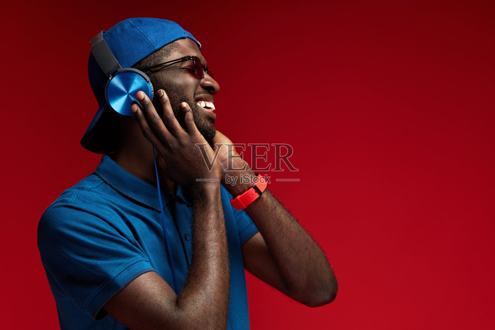 听音乐。微笑的黑人戴着耳机听肖像照片摄影图片