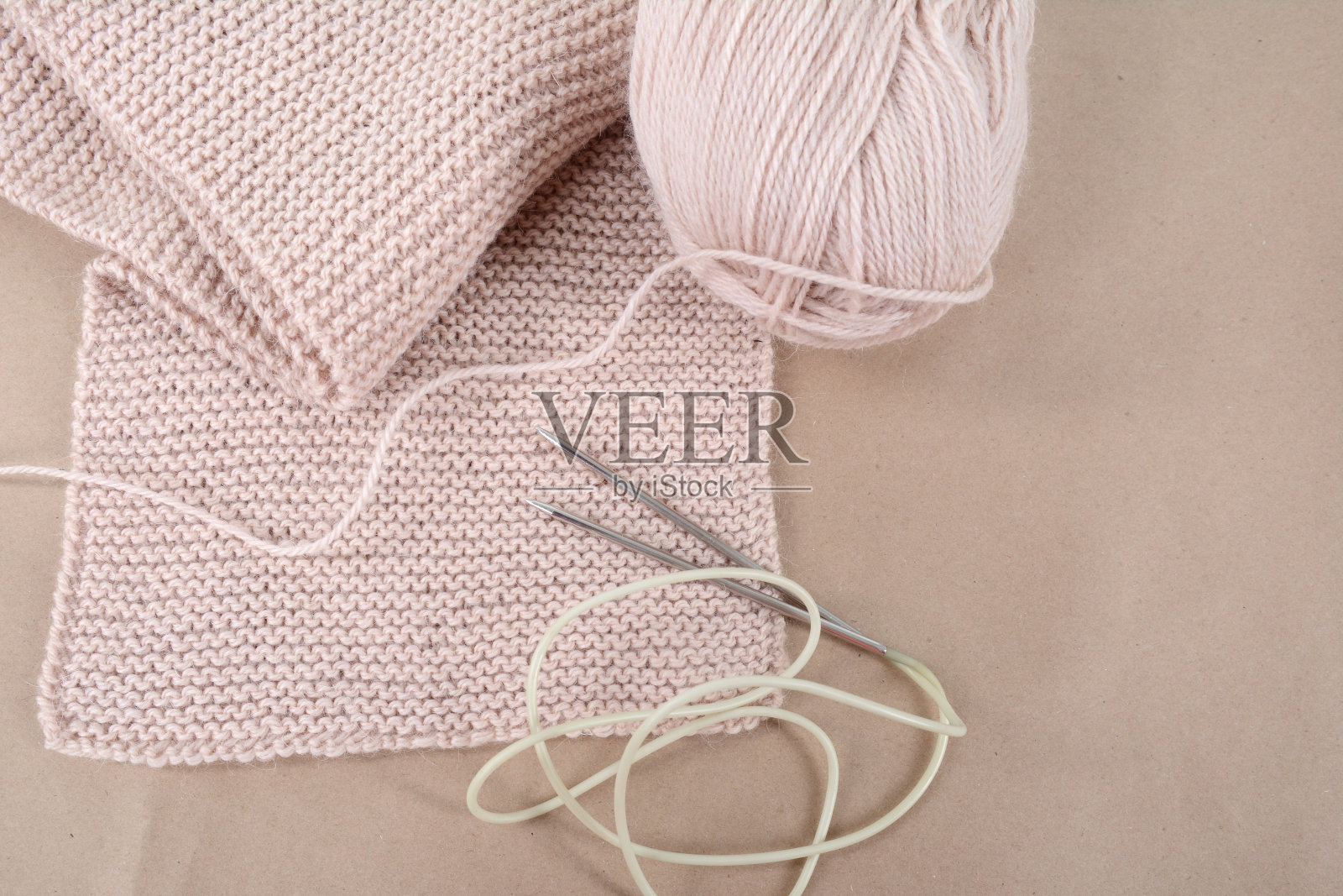 一束羊毛和一条米色线的针织围巾。照片摄影图片
