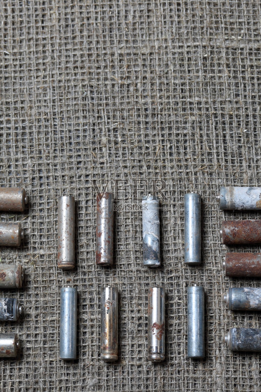 用过的电池躺在粗糙的亚麻布上。覆盖着腐蚀。回收利用，保护环境。照片摄影图片