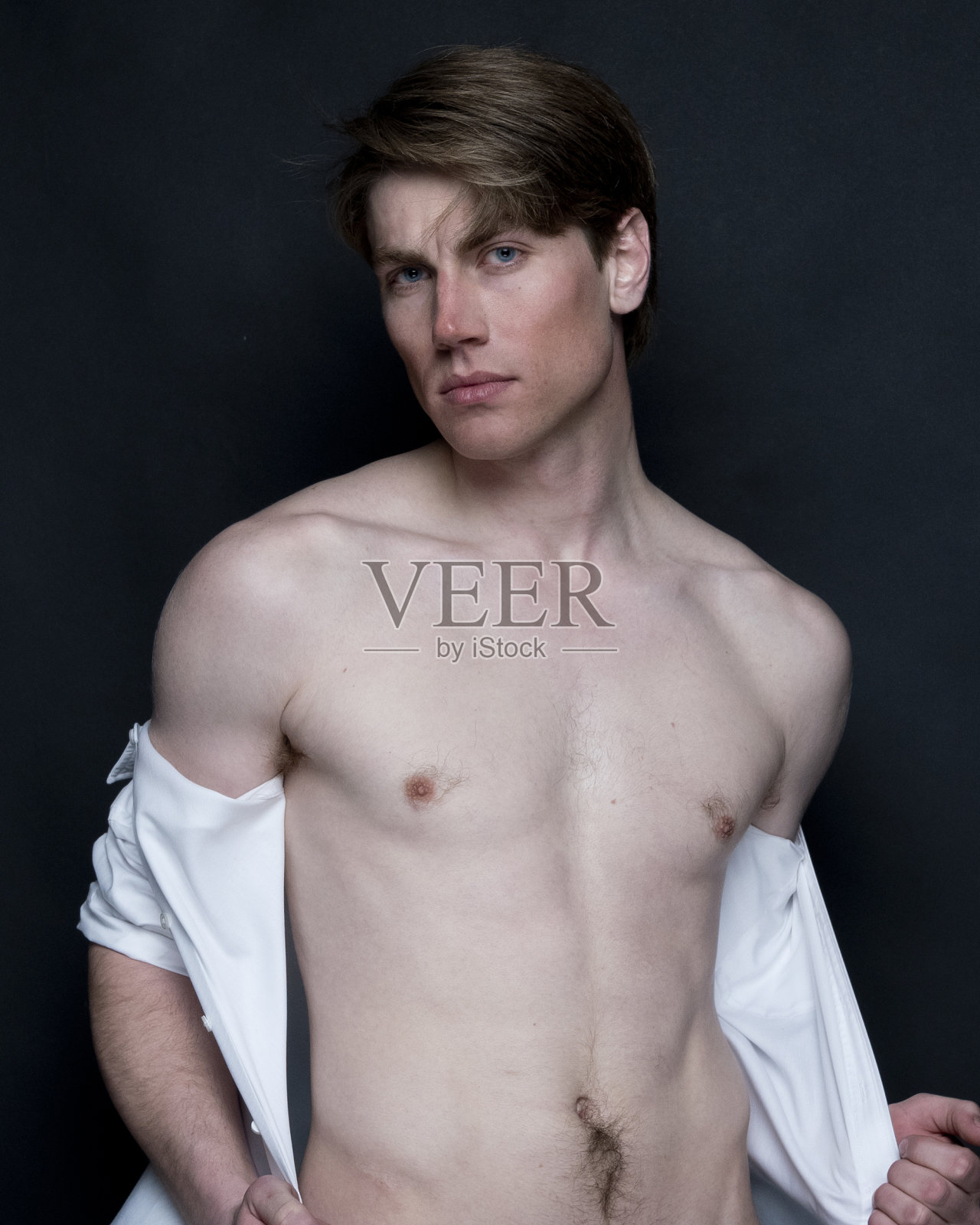 性感男人在黑色背景下炫耀照片摄影图片