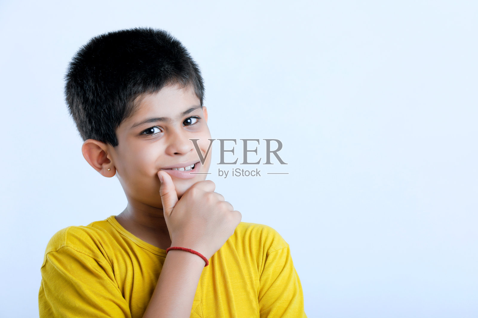 年轻可爱的印度孩子站在白色的背景照片摄影图片