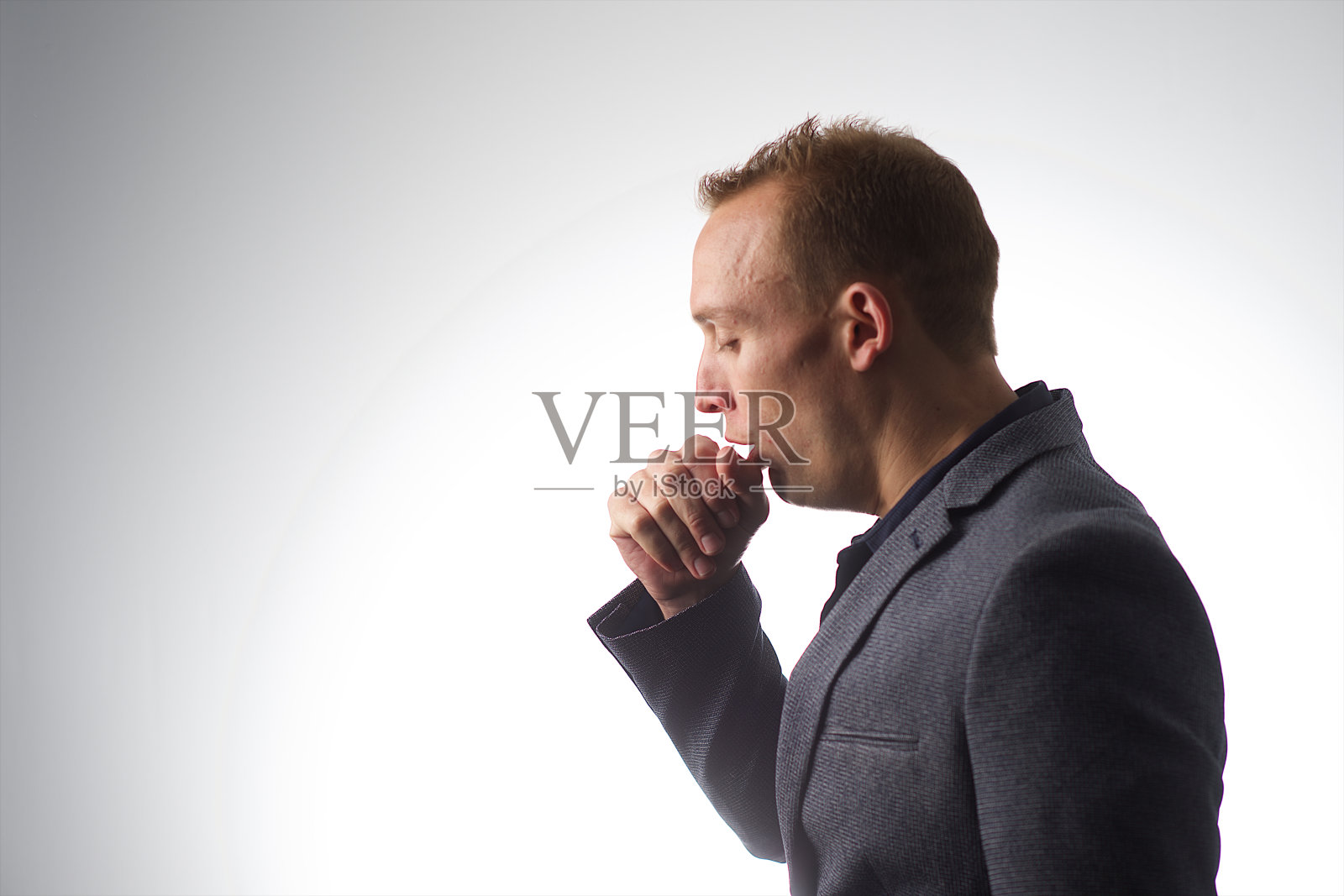 侧面的一个年轻男性咳嗽工作室白色背景照片摄影图片