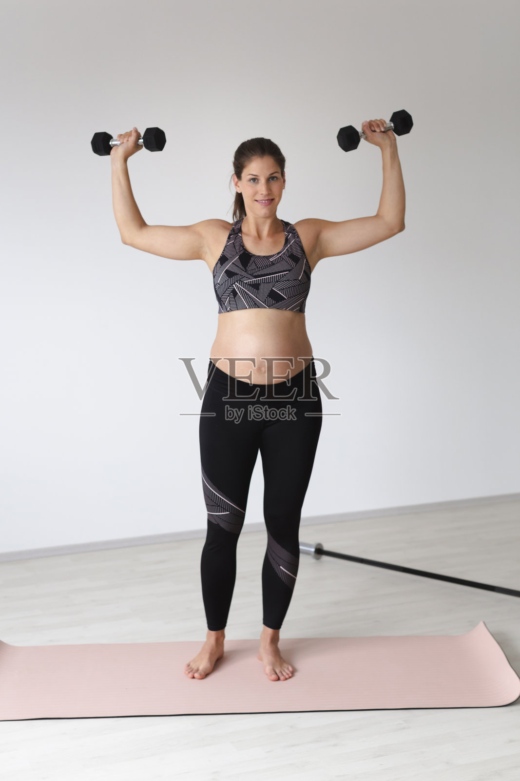 一位年轻漂亮的孕妇正在一间现代公寓里做健身运动，图伦，下奥地利照片摄影图片