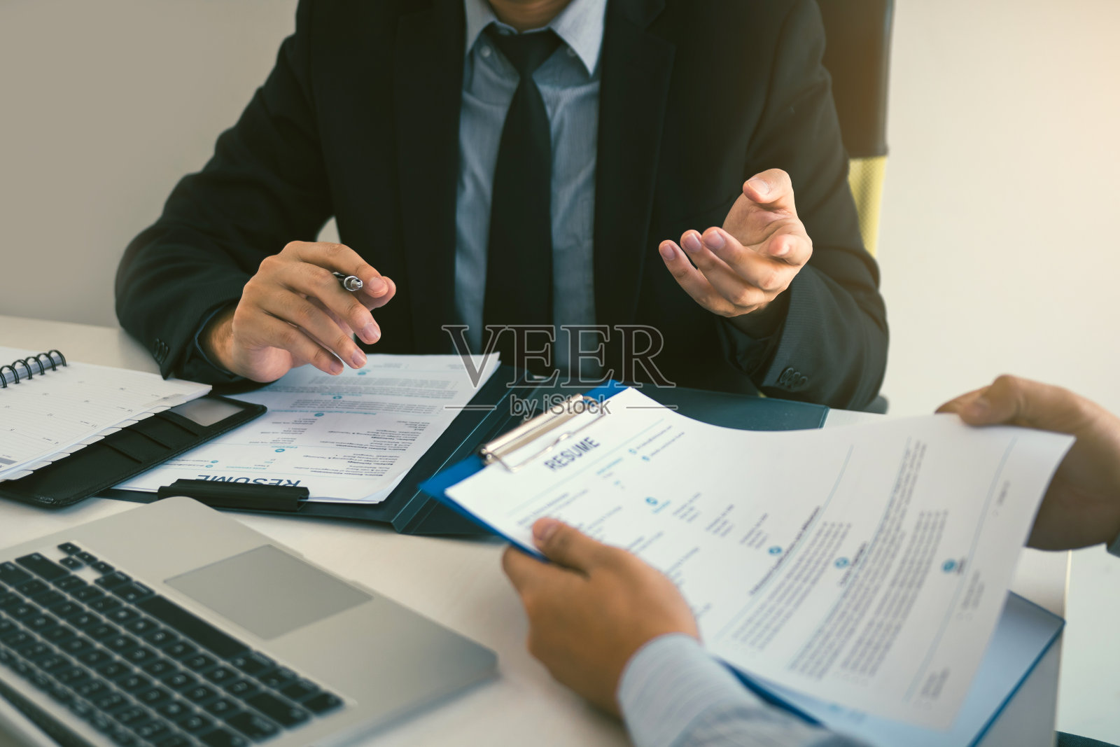 在现代的办公室里，精明的商人、西装革履的专业人士、行政人员在会议上与员工谈论工作。照片摄影图片