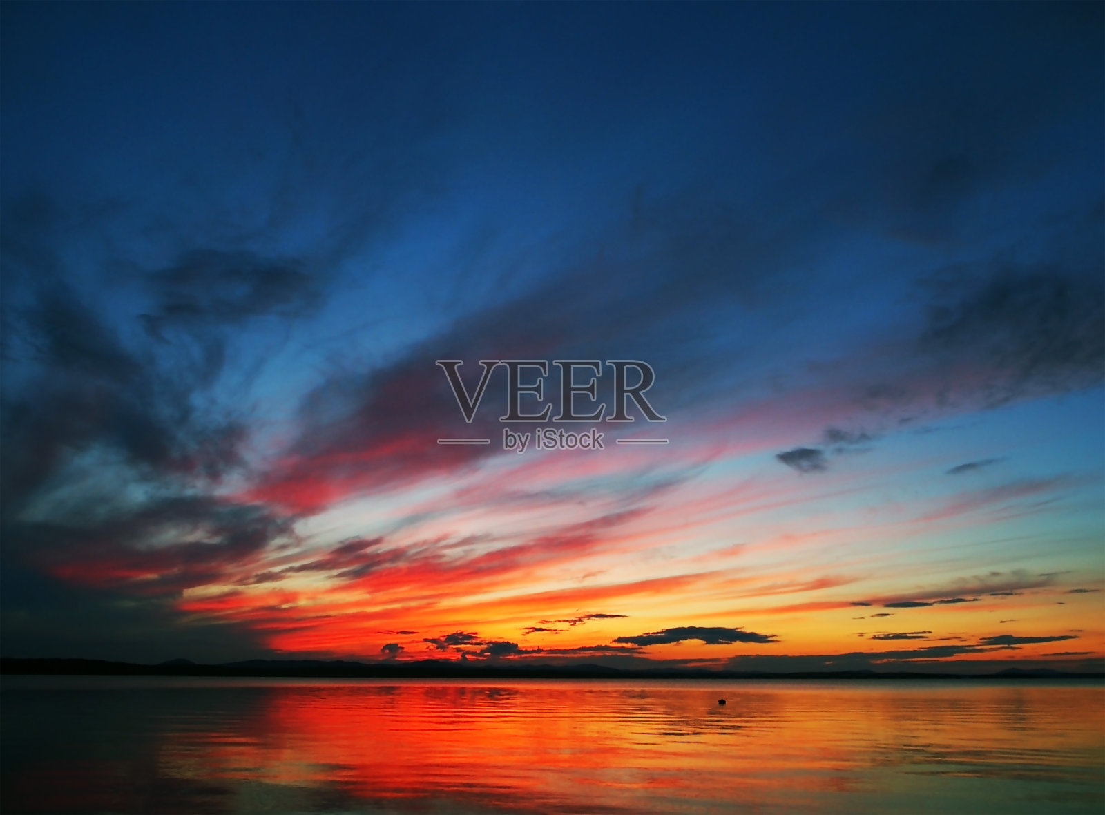 湖面上红色的晚霞天空，戏剧性的灯光照片摄影图片