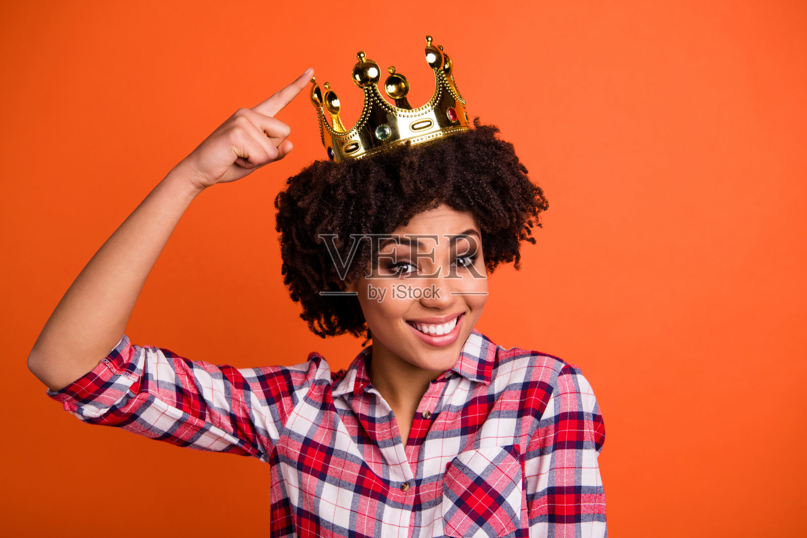 近距离的照片波浪可爱的女士金色皇冠头挑逗暗示头饰手指穿休闲格子衬衫风格孤立橙色明亮的背景照片摄影图片